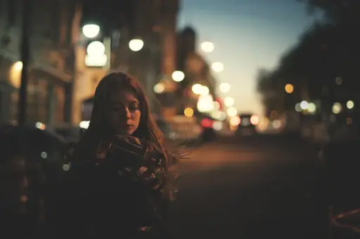 女人在夜晚独自站在城市里