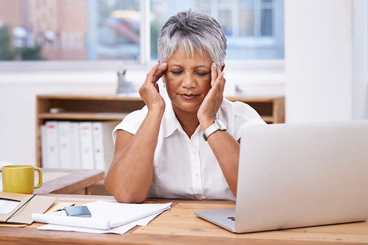 工作中偏头痛的妇女。