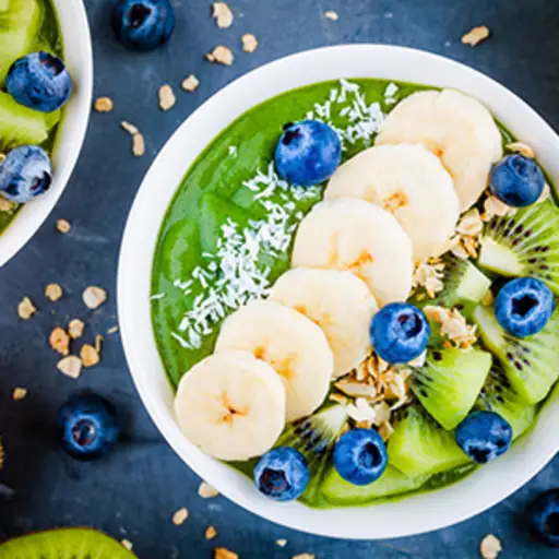 绿色圆滑的人碗用香蕉，猕猴桃，蓝莓，格兰诺拉麦片。