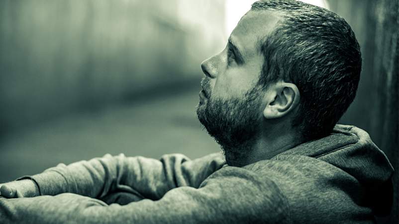 受压迫的人坐在一个隧道。