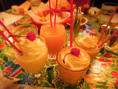 在派对桌上放四种水果鸡尾酒。