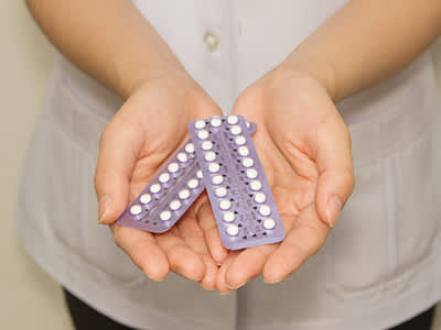 女子抱着避孕药。