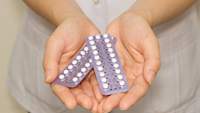 女子抱着避孕药图像。
