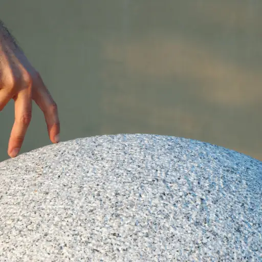 手指从左到右走在花岗岩球体的顶部。