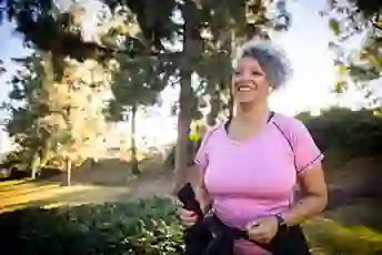 A woman walks outside while wearing a fitness watch