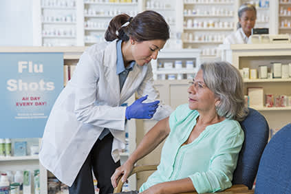 在药房接受年度流感疫苗注射的老年妇女。