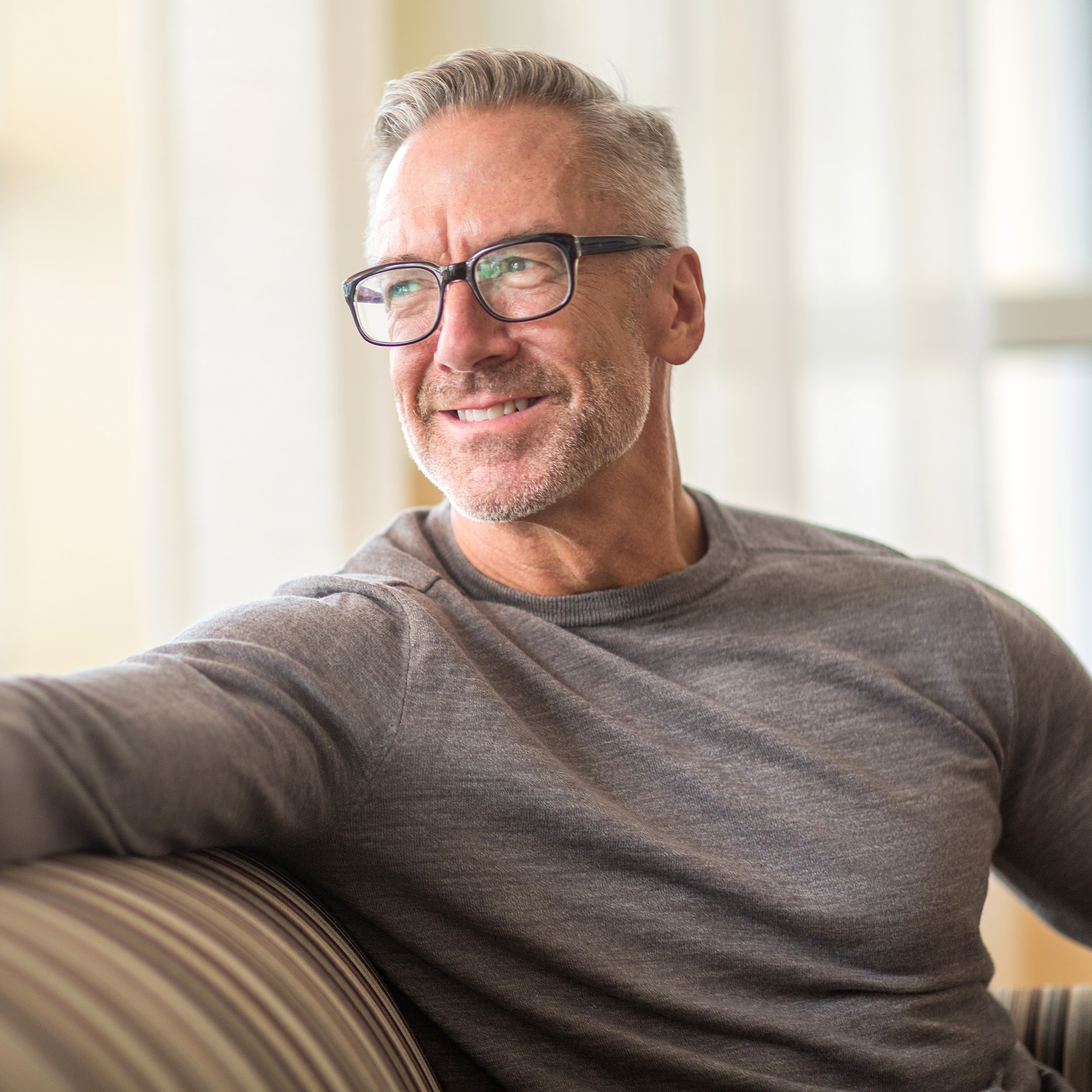 戴眼镜的中年男子笑着看着窗外