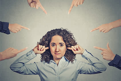 人的女人用手指堵住耳朵堵他们指点。