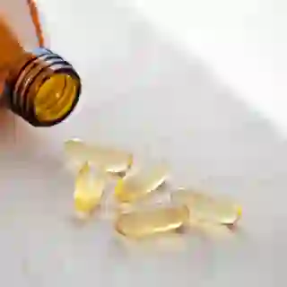 Several vitamin D pills next to bottle
