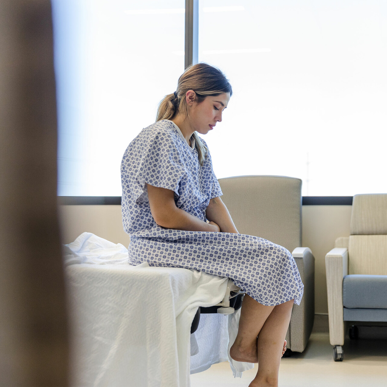 一个生病的女人坐在医院的病床上