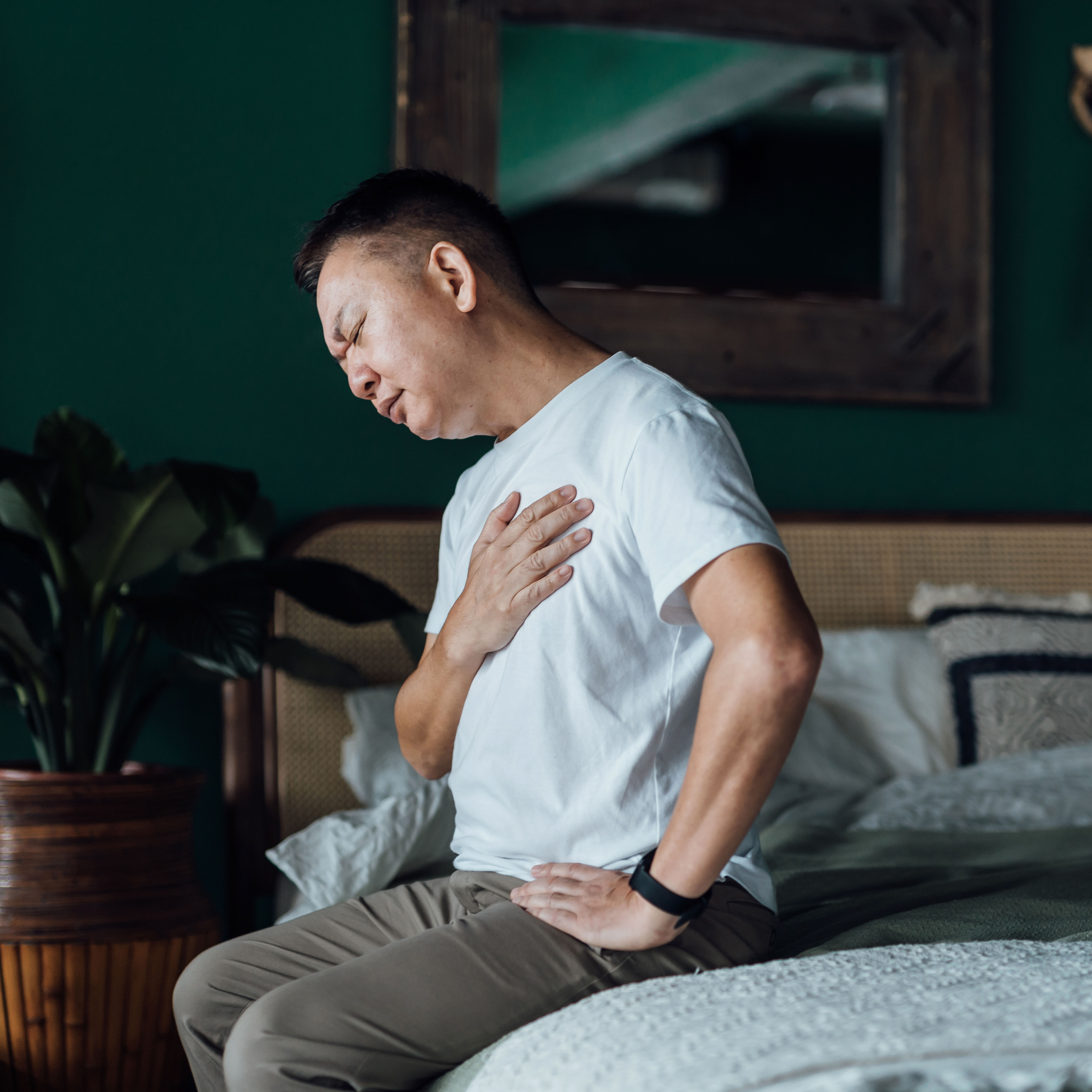一名男子在床上感到胸痛