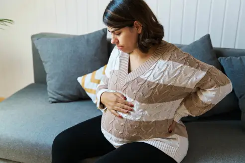 A pregnant woman touches her belly