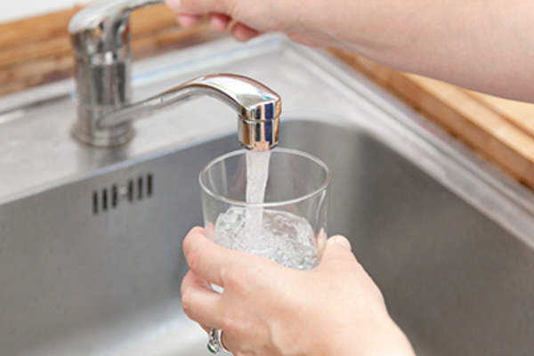 把自来水倒进杯子里的女人。