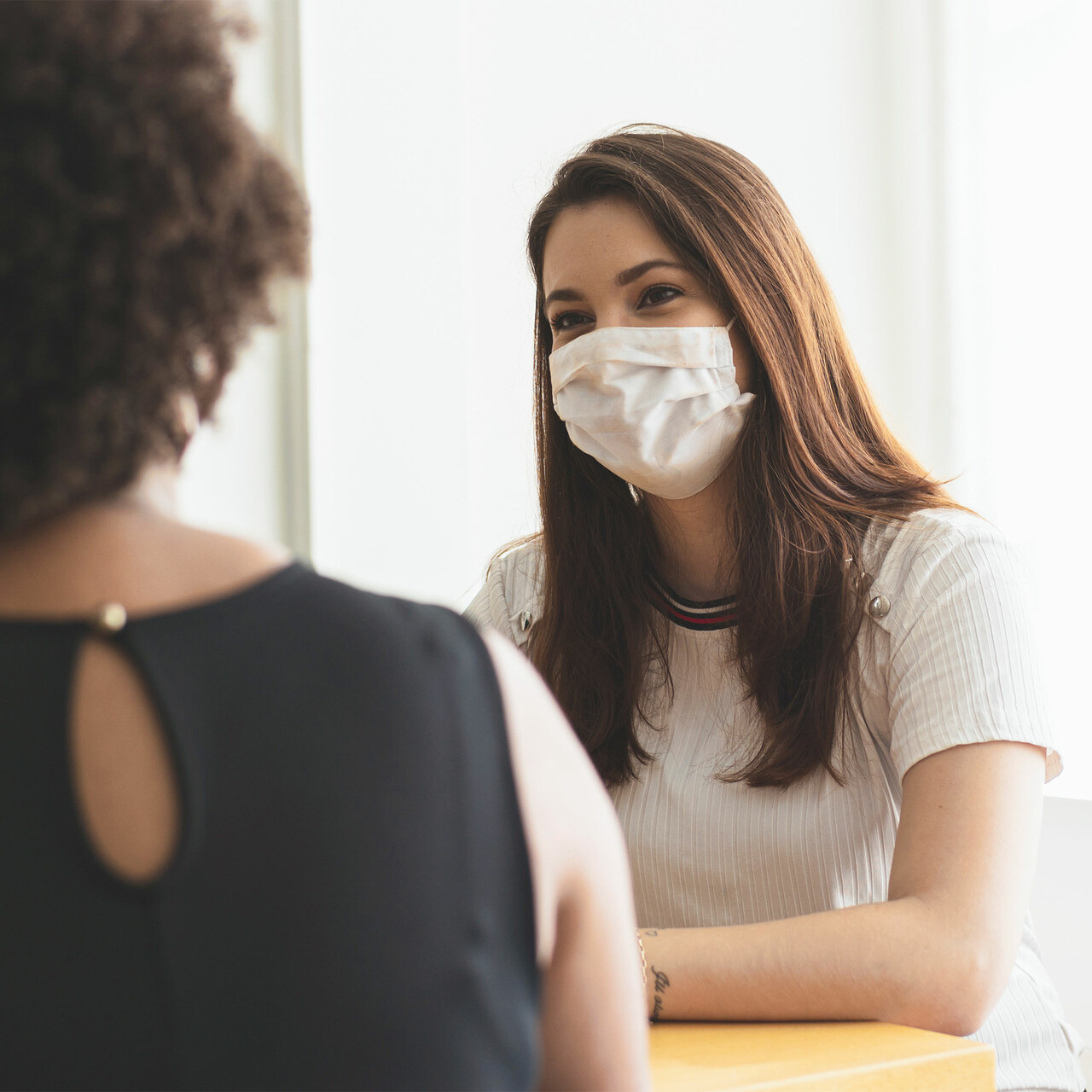 一个戴着面具的女人在办公室里和某人说话