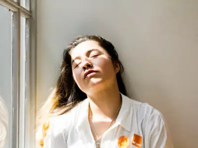 年轻疲倦的女人在阳光下闭着眼睛