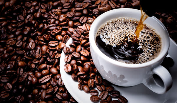 用杯子盛满咖啡，周围放上咖啡豆