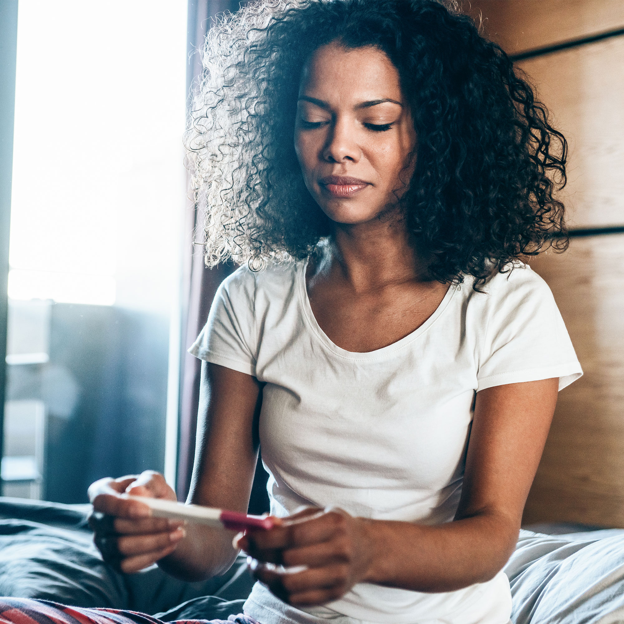 A woman looks at a pregnancy test