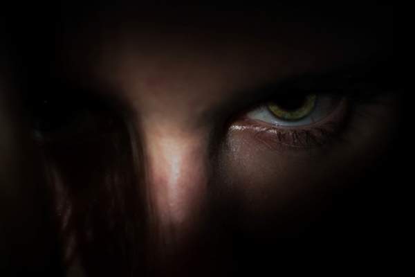 愤怒的男人的眼睛从阴影中出来