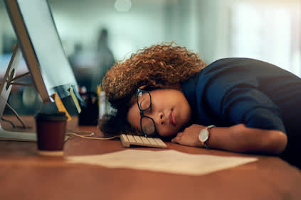 在办公桌前睡着的女人。