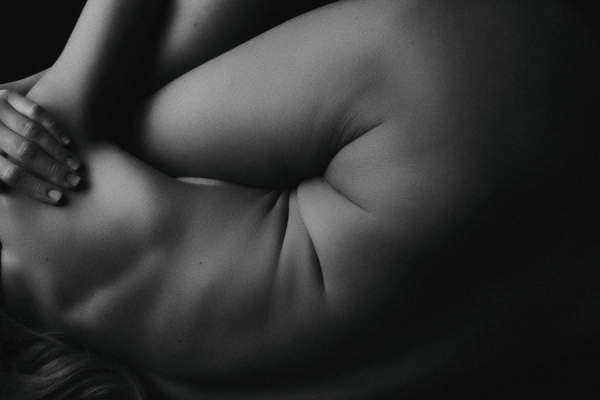 女人的黑白图像蜷缩，展现胃