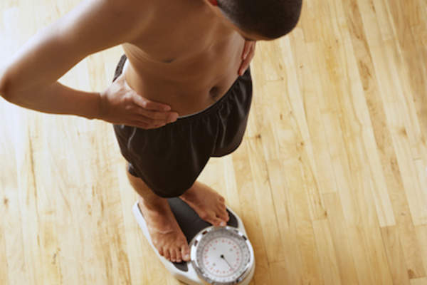 男人在浴室称体重。