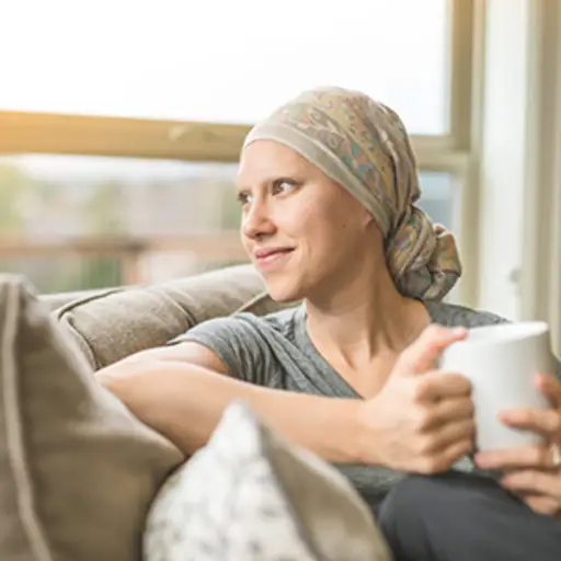 年轻的成年女性癌症患者喝着茶。