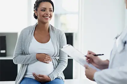 微笑的孕妇和她的医生。