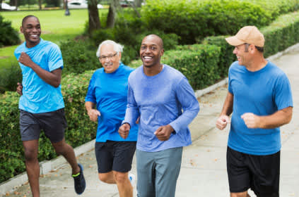 微笑着慢跑的男人和穿着蓝色衬衫的结肠癌意识。
