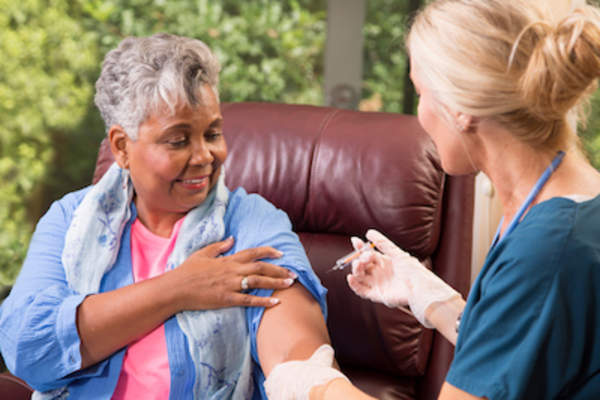 老年妇女从家庭保健专家那里获得带状疱疹疫苗。