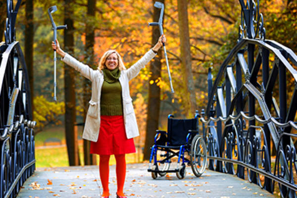 快乐的女人举起拐杖。