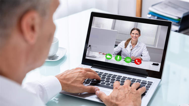 医生和病人在笔记本电脑上视频聊天。