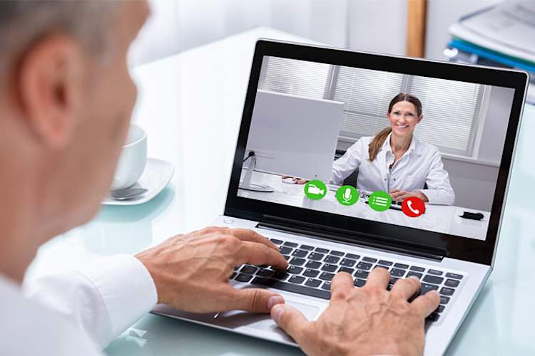 医生和病人在笔记本电脑上视频聊天。