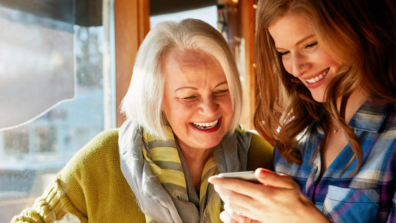 成年的女儿和年迈的母亲笑眯眯地看着照片。