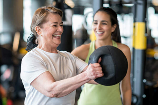 微笑着和教练一起锻炼。