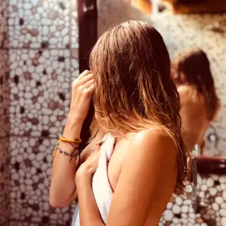 Woman in towel looking in mirror