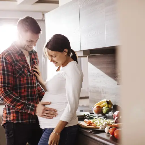 一对怀孕的夫妇在厨房有说有笑