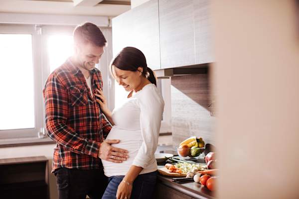 怀孕的夫妇在厨房里有说有笑