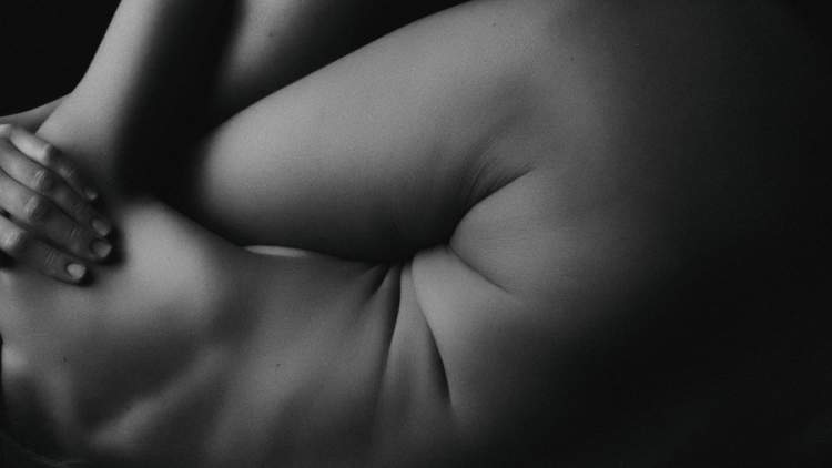 女人的黑白图像蜷缩在一边，集中展示胃