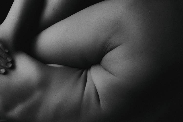 女人的黑白图像蜷缩在一边,集中展示胃