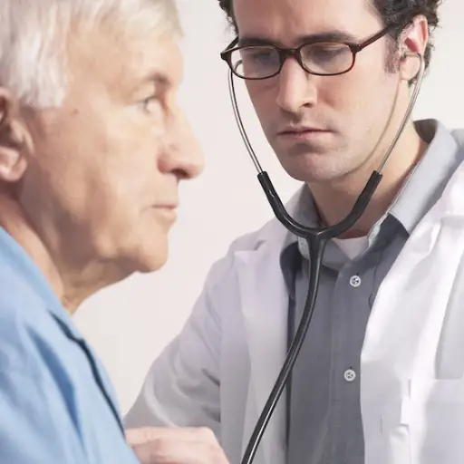 医生用听诊器听老人的心脏。