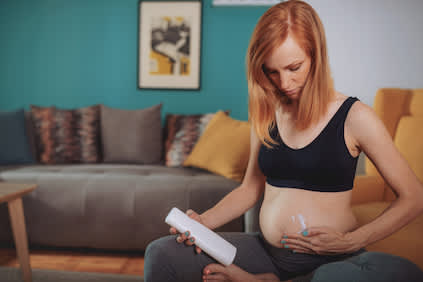 女性在腹部使用乳液来帮助防止妊娠纹。