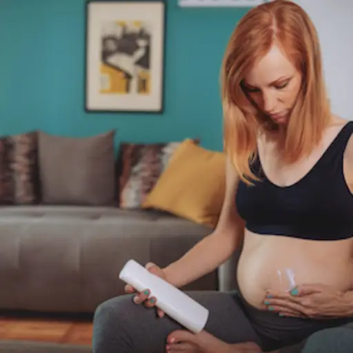 女人在腹部使用乳液，帮助预防妊娠纹。