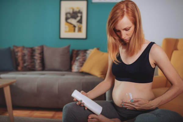 女性在腹部使用乳液来帮助防止妊娠纹。