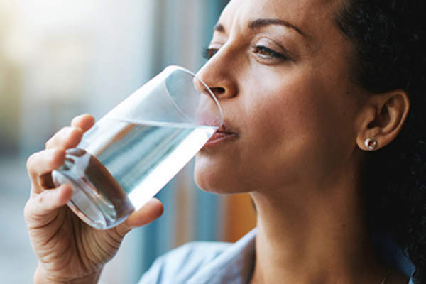 女人喝着一杯水。