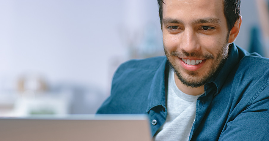 Portret van een jonge man die zijn laptop gebruikt
