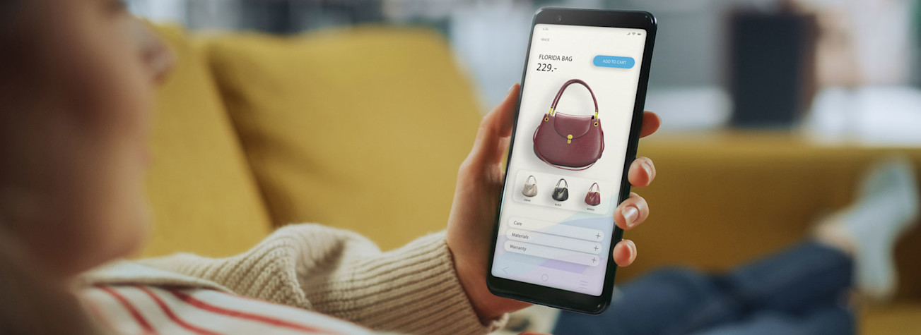 Vrouw bekijkt een tas in een webwinkel op een smartphone