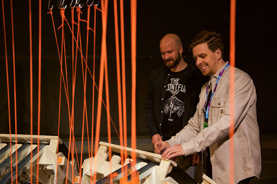 Lei Nelissen demonstrates the Packet Run installation to a visitor at Dutch Design Week 2023