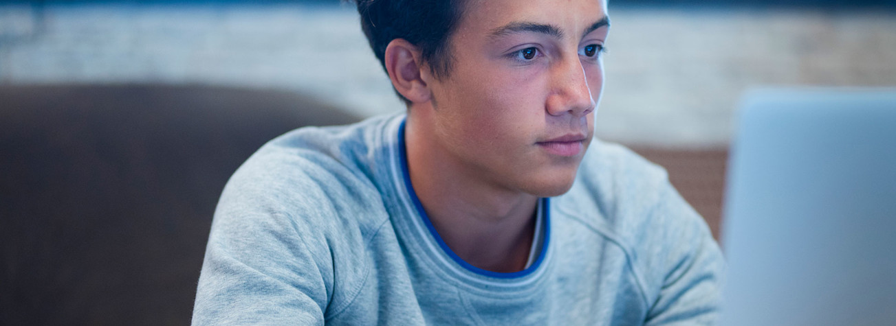 Teenager working on his laptop