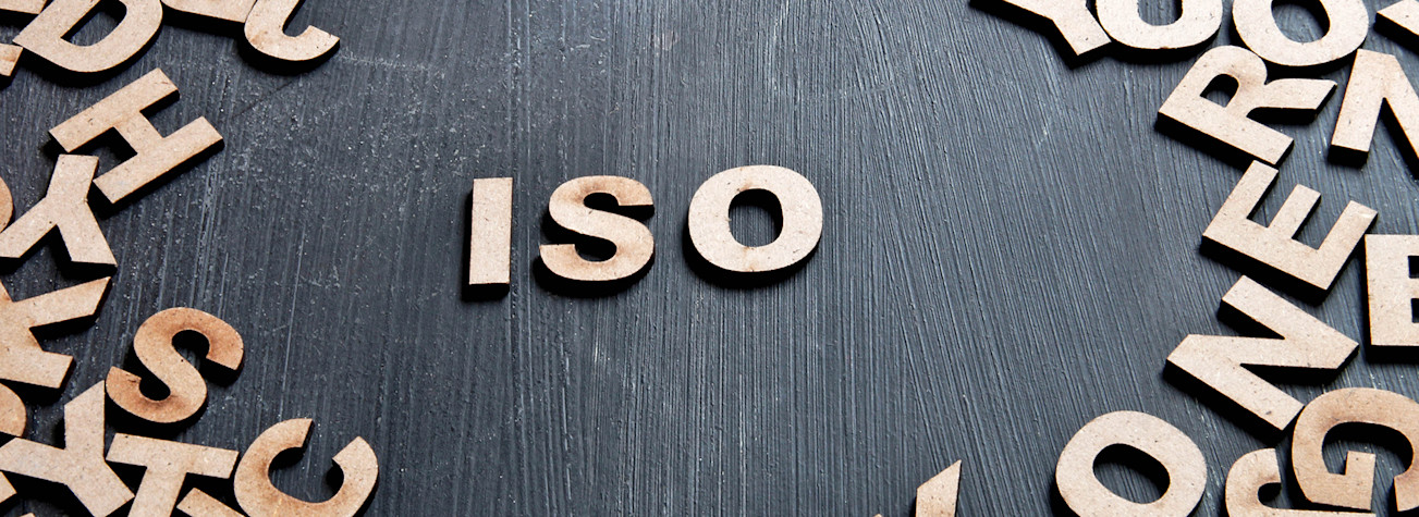 Abbreviation ISO in wooden letters in the middle of a collection of letters