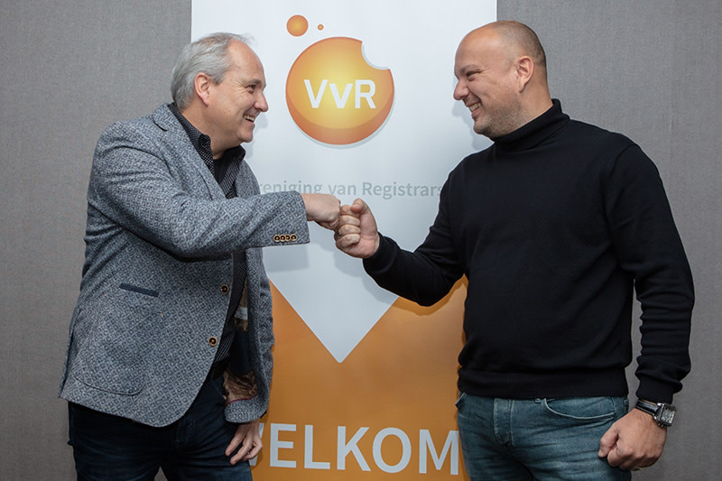 Berend van Dalfzen, chairman of the Registrars Association, and Martijn Kamphuis, former chairman, give each other a fist bump to ratify the change of chairmanship.